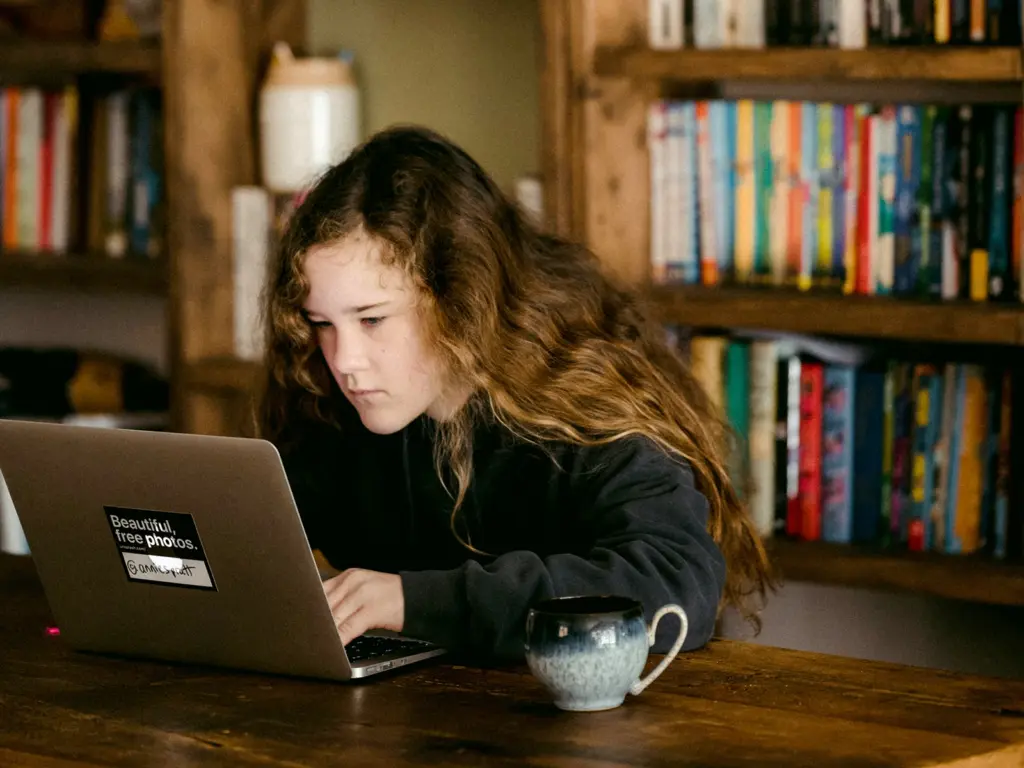 Jugendliche sitzt konzentriert vor Laptop als Symbolbild für die Berufsorientierung