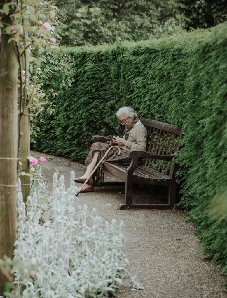 Eine alte Frau sitzt auf einer Parkbank als Symbolbild für Seminare zum Thema Kommunikation am Lebensende